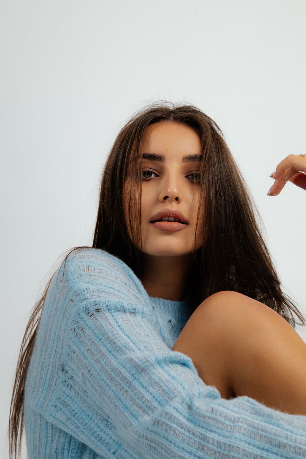 Woman in cozy blue sweater, natural pose.