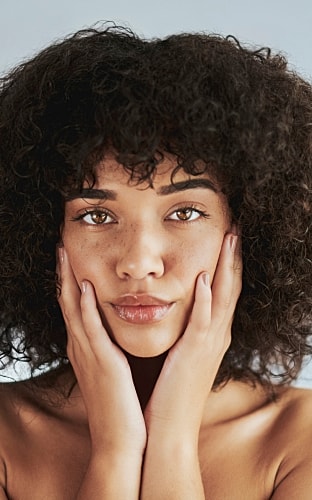 Smiling woman in activewear against a white wall.