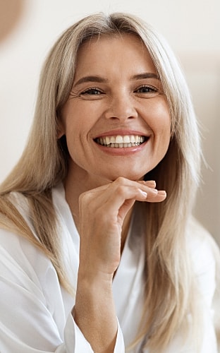 Model posing in black activewear on white pedestal.